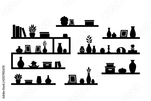 Minimalist black silhouette home decor on shelves with plants and vases.