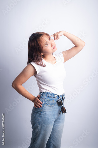 Young woman in casual denim and white tee pointing to temple