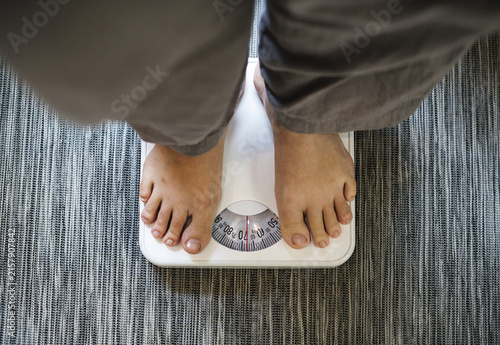 feet on scale. woman standing scale. Legs of young woman standing on scale to measure weight in room. Female feet with weight scale at home.