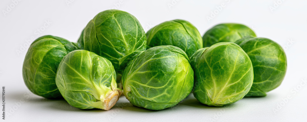 Obraz premium Fresh green Brussels sprout vegetable close up with natural texture and vibrant color on white background, healthy food concept