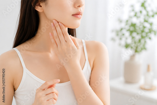 首の肌に触れて状態を確認する女性の美容と年齢のイメージ