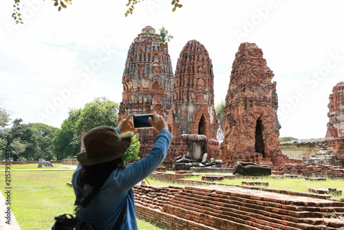 Tourists are using their mobile phones to take pictures of the ruins of Wat Mahathat (A group of ancient brick stupas and pagodas) , located in the Ayutthaya Historical Park, Ayutthaya Province. 
