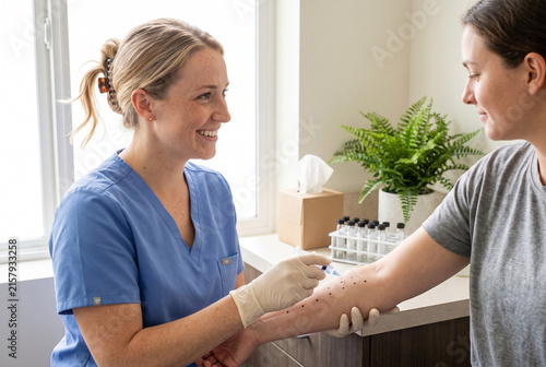 Allergy testing by an allergist in a bright medical clinic with smiling patient