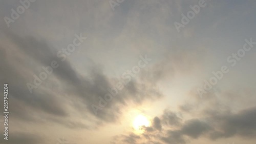 Time-lapse of a soft glowing sun shining through moving overcast clouds and haze. Peaceful atmospheric nature background for weather and time concepts.