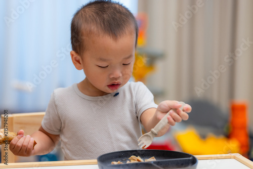 Little boy holding fork eating