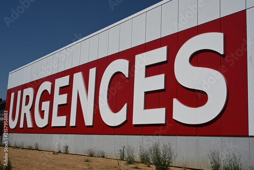 Fotografía un grand mur blanc avec l'inscription urgences en grosses lettres blanches peintes sur un rectangle rouge