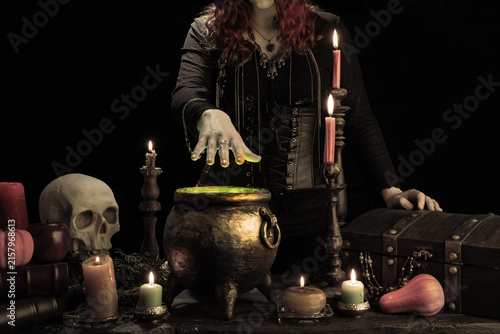 Obraz na płótnie Witch casts spell, cauldron, boiling magic potion, candles, skull