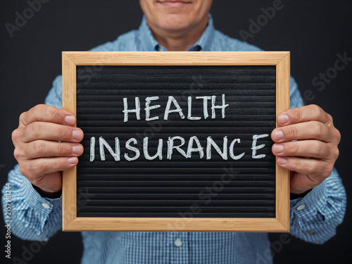Senior man holding health insurance message board
