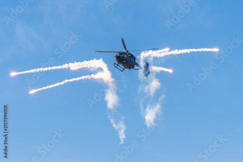 Black modern military transport helicopter shrouded in smoke over Budapest