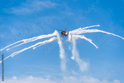 Black modern military transport helicopter shrouded in smoke over Budapest