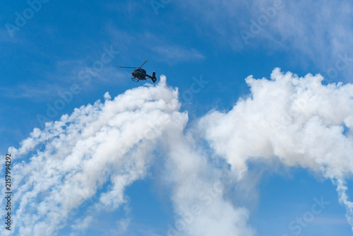 Black modern military transport helicopter shrouded in smoke over Budapest