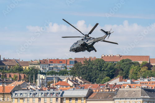 Black modern military transport helicopter flying over Budapest, Hungary