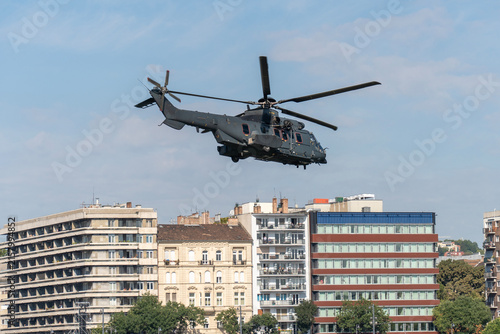Black modern military transport helicopter flying over Budapest, Hungary