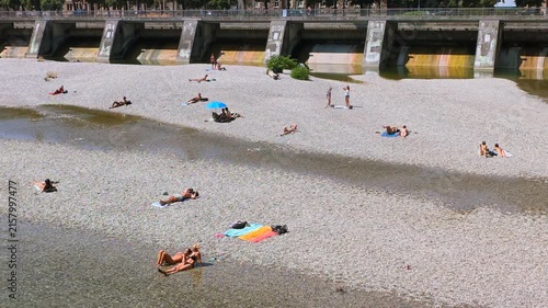 Menschen erfrischen sich am Ufer der kühlen Isar an einem heißen Sommertag, München, Oberbayern, Bayern, Deutschland