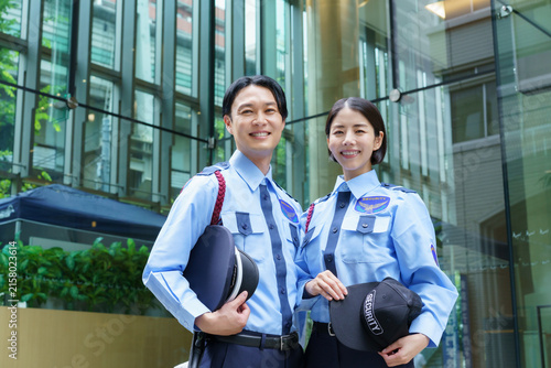 Photography オフィスビルの前に立つ若い日本人男性警備員と女性警備員のポートレート　撮影協力：学校法人電波学園　東京電子専門学校