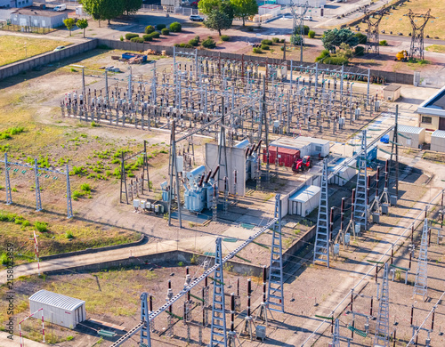 Aerial view of a high voltage electrical substation with power transformers, transmission equipment, and switching infrastructure in Saulce-sur-Rhone, Auvergne-Rhone-Alpes, France.
