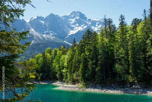 Travel landscape of Zugspitze Alps in Bavaria, Germany, scenic summer nature panorama with forest, Eibsee lake, snow mountains peak. Alpine landscape
