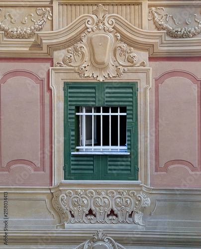 Traditional Ligurian trompe l oeil painted window facade with real white iron guardrail in Genoa, Liguria, Italy