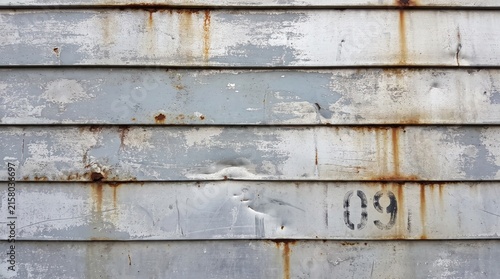 Rusted corrugated metal texture with number 09. Industrial background with worn grey paint. Weathered steel surface for design background.