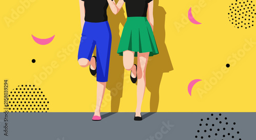 Two young women standing together against a bright yellow wall background