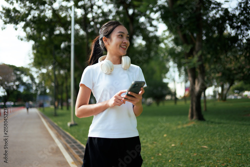 Young Asian woman connecting with technology in park