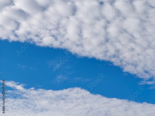 фотографія Aerial view of altocumulus undulatus clouds displaying distinctive wave-like ripple patterns across blue sky, showing characteristic atmospheric undulation and iridescent cloud formations