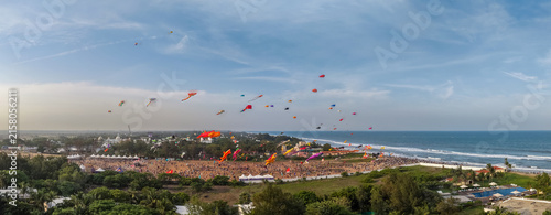 Bild auf Leinwand Colourful kites flying over a coastal kite festival by the sea