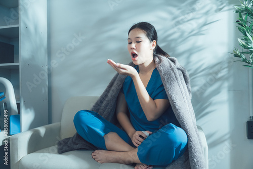 Принти на полотні Feeling Unwell: A young woman wrapped in a blanket, feeling sick and unwell, wit