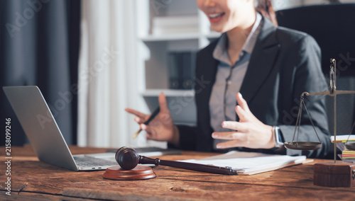 Canvastavla Online Consultation with Legal Professional: A female lawyer in a formal suit is seen engaged in a video conference on her laptop, with a gavel and scales of justice on her desk