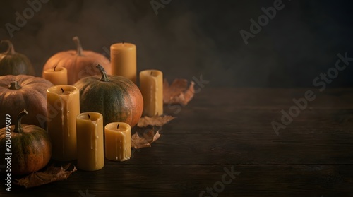 Rustic autumn still life with assorted pumpkins and glowing candles on a dark wooden table background for seasonal decor