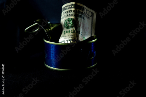 dollar bill inside open metal tin can