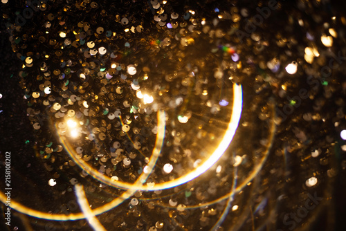 Obraz na plátně Golden glitter particles with warm bokeh, festive