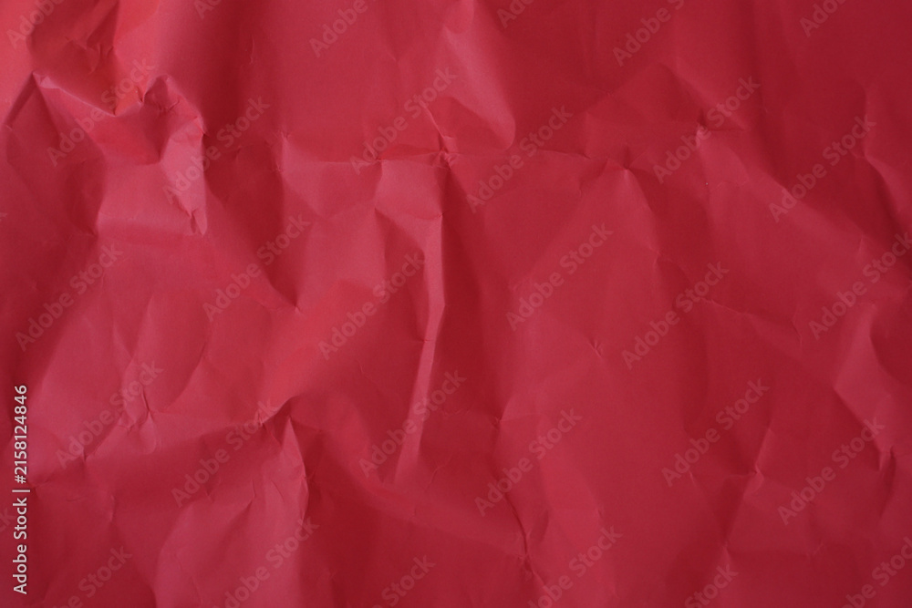 Fototapeta premium Crumpled red paper texture background with deep wrinkles, folds, and subtle shadows