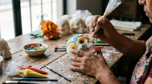Person decorating a sugar skull with icing for Day of the Dead celebration 1.