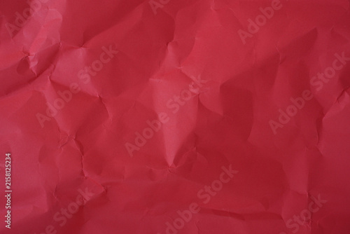 Crumpled red paper texture background with deep wrinkles, folds, and subtle shadows