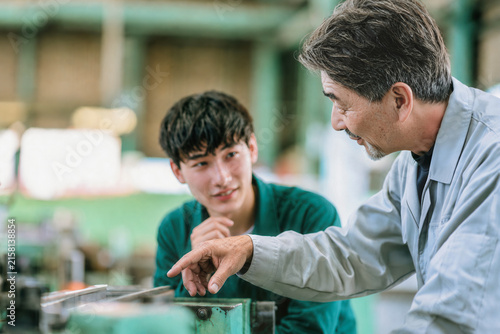 技能継承のため若手社員を教育するベテラン技術者