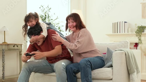 Kid Enjoys Playing Games With Parents at Home on a Playful Day While Having Fun Together