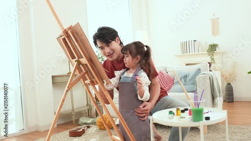 Man and Girl Paint Together in a Bright Room With Plants and Art Supplies Around