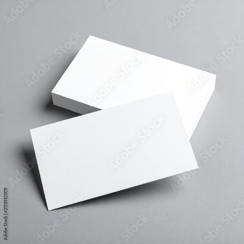 two blank business cards on a grey background