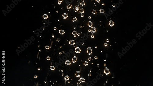 Water droplets falling against a black background.