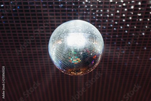 disco ball with mirror surface and bright rays, white light, hanging on ceiling, night party background