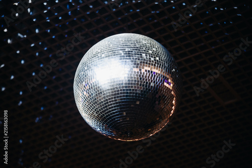 disco ball with mirror surface and bright rays, white light, hanging on ceiling, night party background