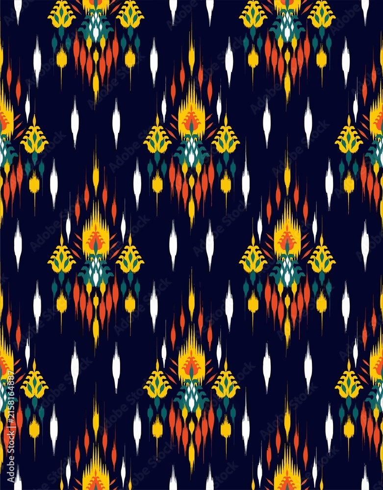 Traditional ethnic ikat seamless pattern with colorful motifs on dark blue