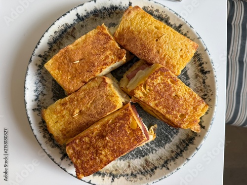 Gourmet Monte Cristo French Toast Ham and Cheese Sandwiches in a Frying Pan and Plated