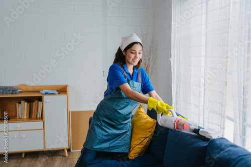 Professional Housekeeper Vacuuming Sofa Modern Living Room Efficient Home Cleaning Service