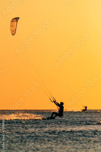 Canvas Print Kiter riding over the sea with a kite in golden light