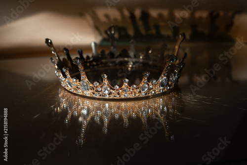 Photography Luxury Golden Crown with Crystal Details and Reflection on Brown Background