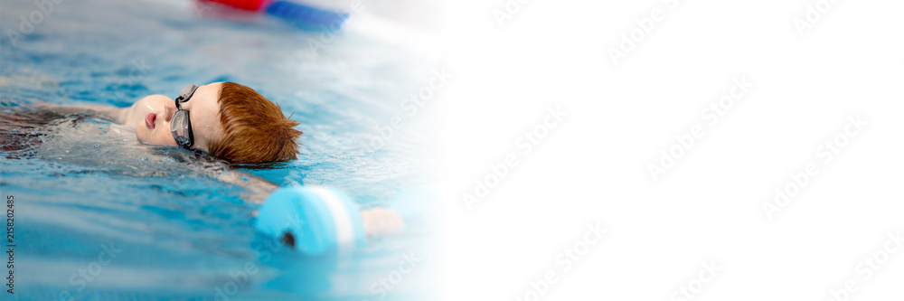 Fototapeta premium A boy in the pool will follow his coach. The child learns to swim crawl. a web banner with space for text and space for copying