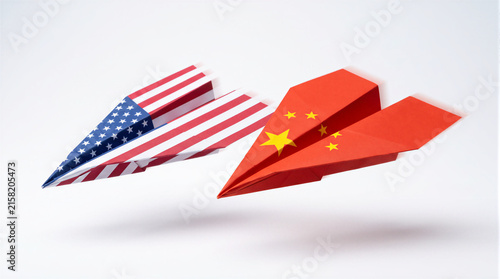 Plakat w ramie Two paper airplanes textured with USA and China flags flying side by side on white background, space race and geopolitical rivalry concept