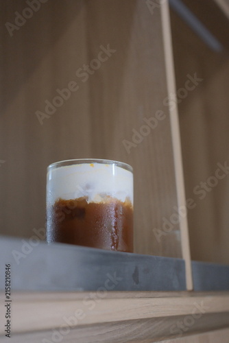 Iced coffee with milk in a glass on a modern concrete surface